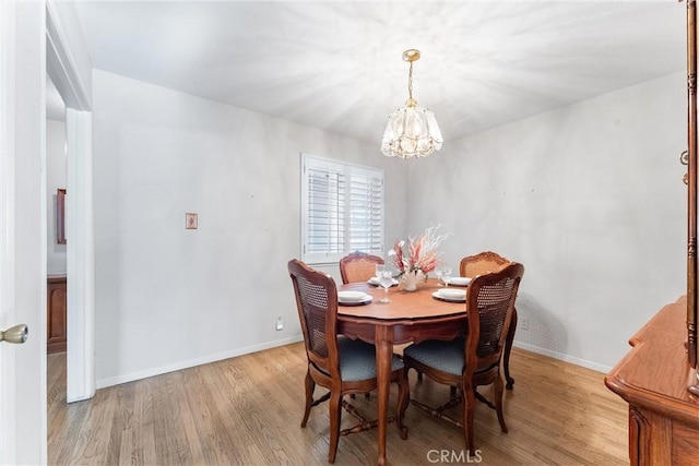 dining room with an inviting chandelier and light hardwood / wood-style flooring