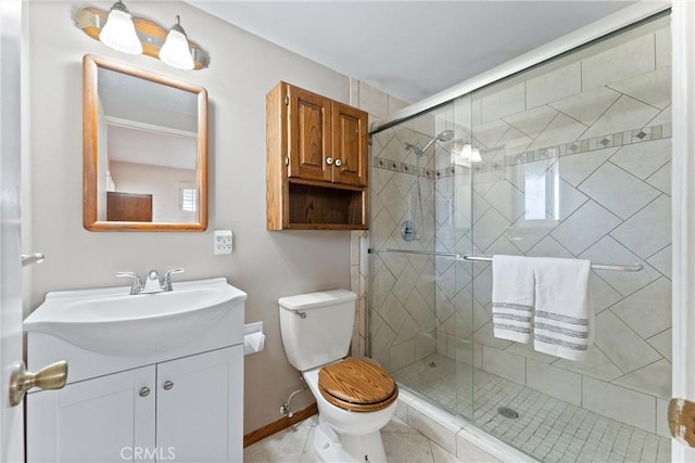 bathroom featuring tile patterned flooring, vanity, toilet, and walk in shower