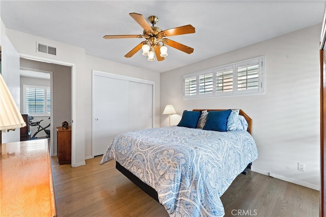 bedroom with wood-type flooring, a closet, and ceiling fan