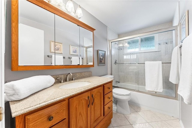 full bathroom with tile patterned flooring, vanity, toilet, and shower / bath combination with glass door