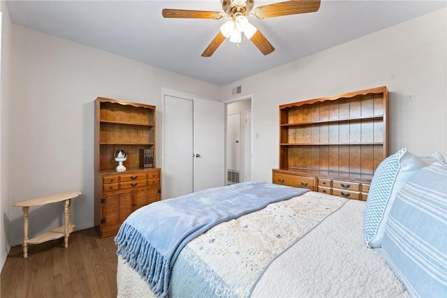 bedroom with ceiling fan, dark hardwood / wood-style floors, and a closet