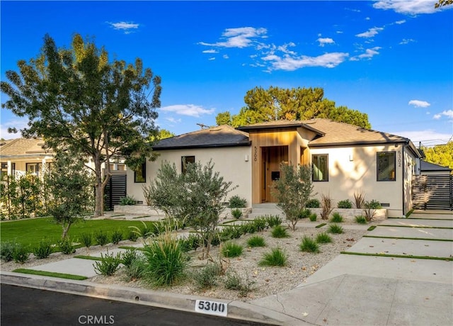 view of front of house with stucco siding and a front lawn