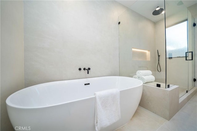 bathroom featuring separate shower and tub and tile walls