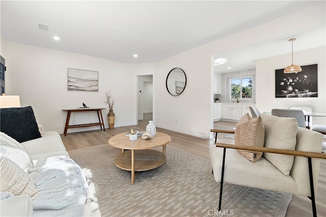 living room with light hardwood / wood-style flooring and sink