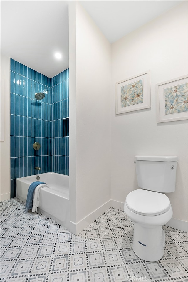 bathroom featuring tile patterned floors, tiled shower / bath combo, and toilet