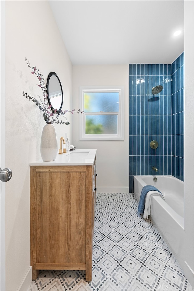 bathroom with tiled shower / bath combo and vanity