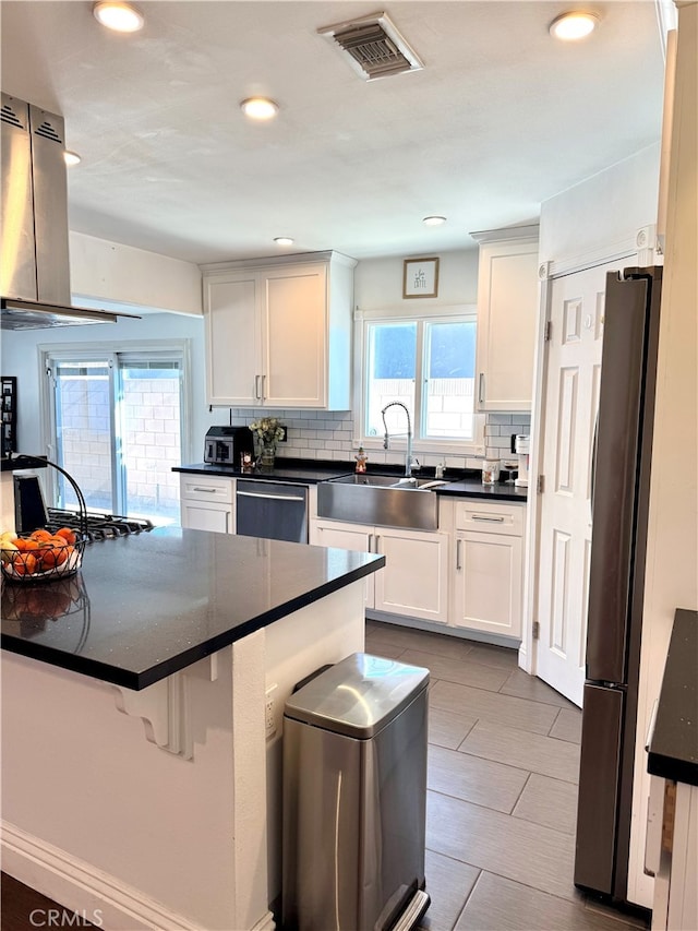 kitchen featuring white cabinets, appliances with stainless steel finishes, backsplash, and sink