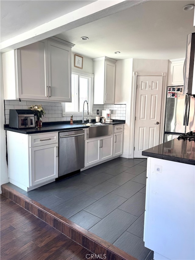 kitchen with white cabinets, appliances with stainless steel finishes, and tasteful backsplash