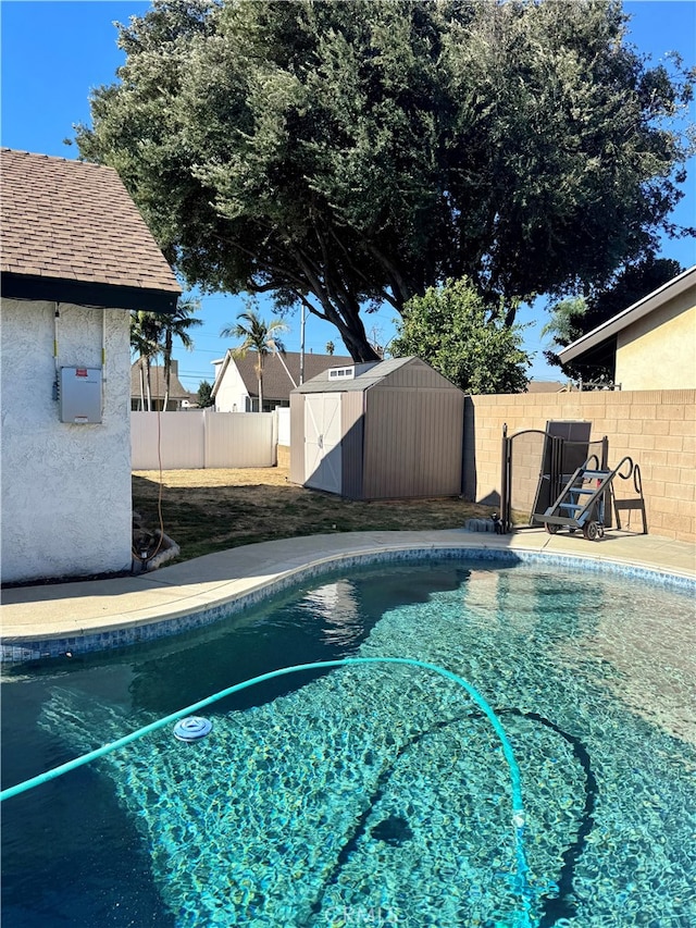 view of swimming pool with a storage unit