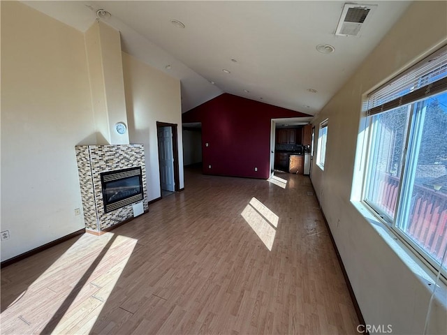 unfurnished living room featuring a fireplace, hardwood / wood-style floors, and vaulted ceiling