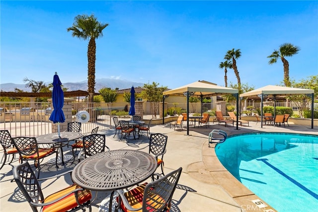 view of swimming pool with a mountain view and a patio