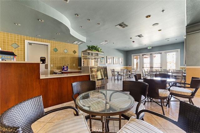 tiled dining area featuring french doors