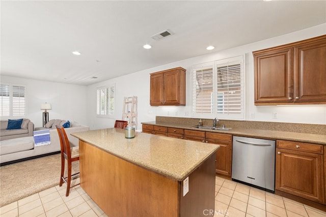 kitchen featuring dishwasher, light tile patterned floors, a kitchen island, and sink