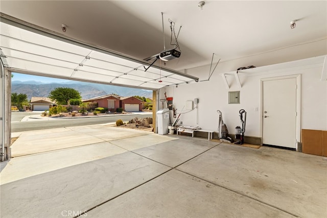 garage featuring electric panel, a mountain view, and a garage door opener