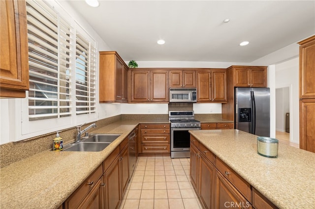 kitchen with light stone counters, sink, light tile patterned floors, and stainless steel appliances