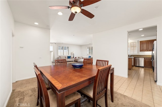 carpeted dining area with ceiling fan