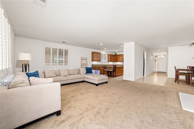 carpeted living room featuring ceiling fan