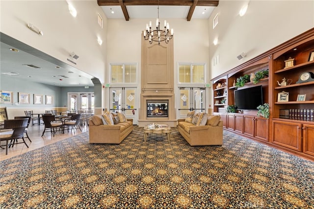 living room featuring beamed ceiling, french doors, a notable chandelier, and a high ceiling