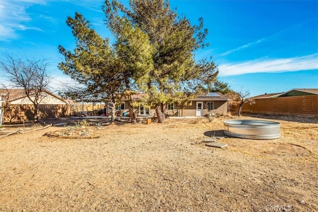 back of house featuring a swimming pool and solar panels