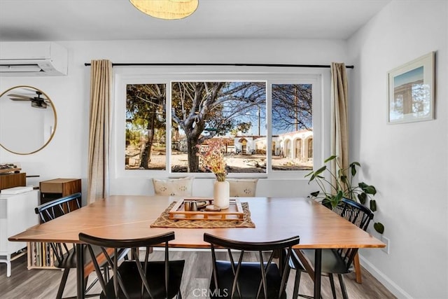 dining room with a wall mounted air conditioner, breakfast area, and wood-type flooring