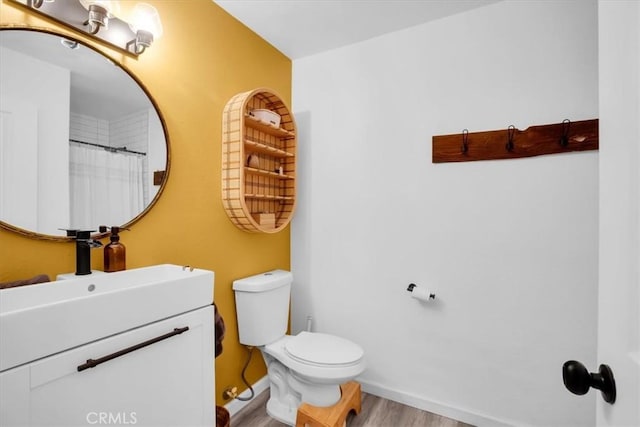 bathroom with hardwood / wood-style floors, vanity, and toilet