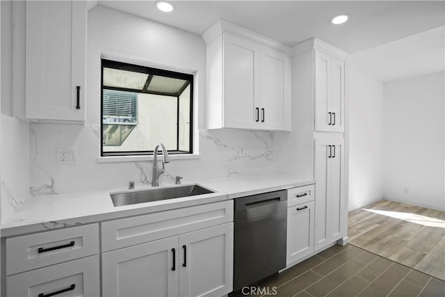 kitchen with white cabinets, tasteful backsplash, stainless steel dishwasher, and sink