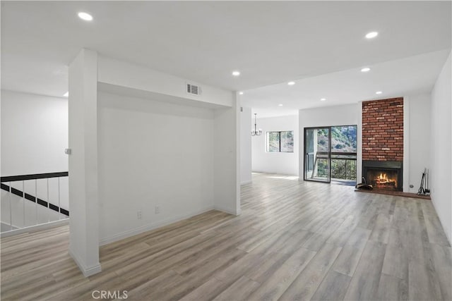 unfurnished living room with a fireplace and light wood-type flooring