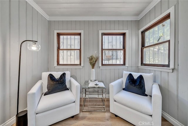 living area with light hardwood / wood-style flooring and ornamental molding