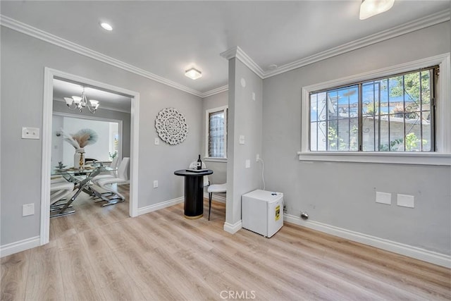 foyer with crown molding, light hardwood / wood-style flooring, and a notable chandelier