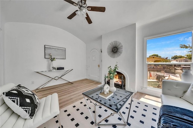 living room featuring a wealth of natural light, light hardwood / wood-style flooring, ceiling fan, and lofted ceiling