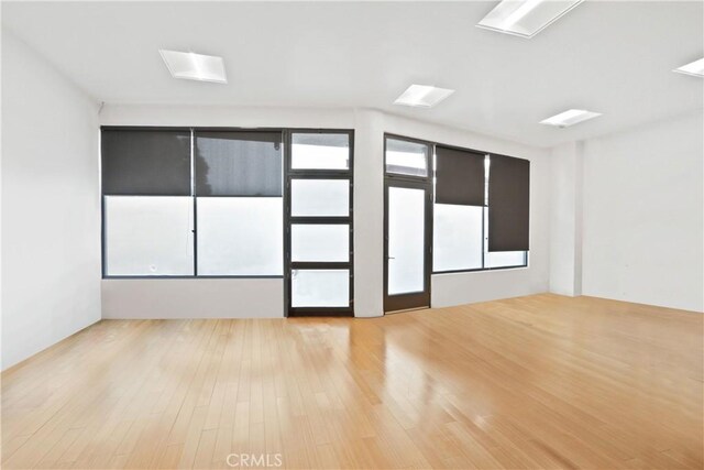 spare room featuring a wealth of natural light and light hardwood / wood-style flooring