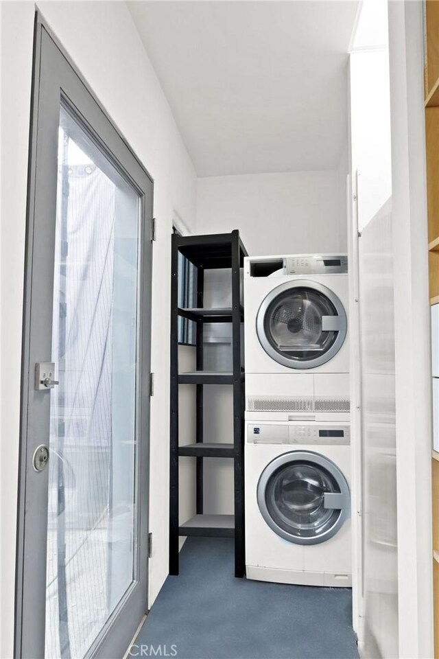 washroom featuring stacked washer and dryer