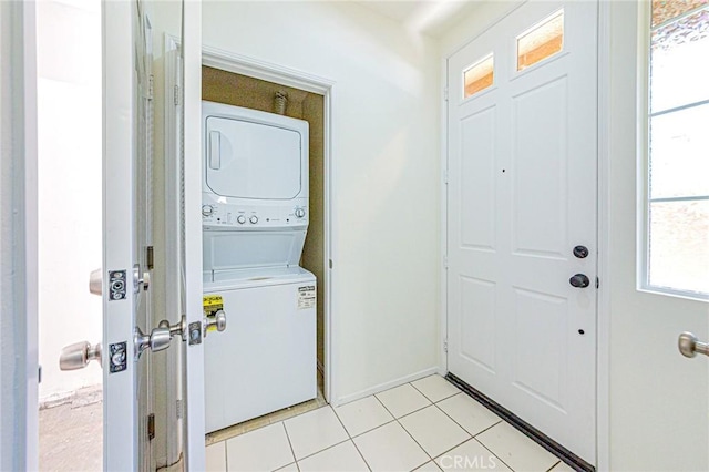 laundry area featuring light tile patterned floors and stacked washer / drying machine