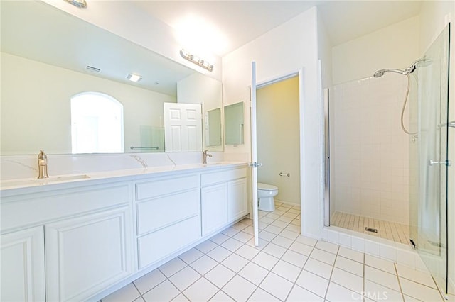 bathroom with walk in shower, vanity, tile patterned floors, and toilet