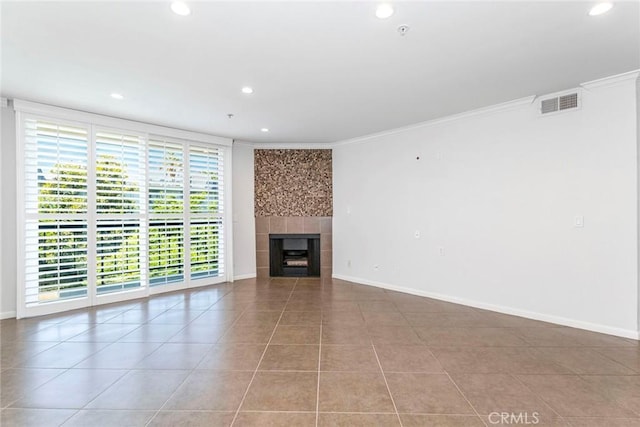 unfurnished living room featuring a tiled fireplace, tile patterned flooring, and ornamental molding