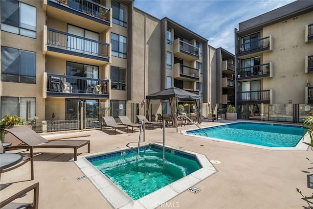 view of pool featuring a patio and a hot tub