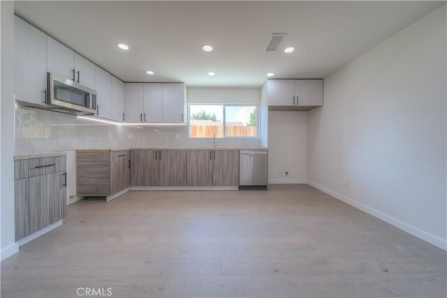 15570 Ethel St, Chino Hills, CA 91709 - kitchen featuring visible vents, light wood-style flooring, stainless steel appliances, light countertops, and a sink