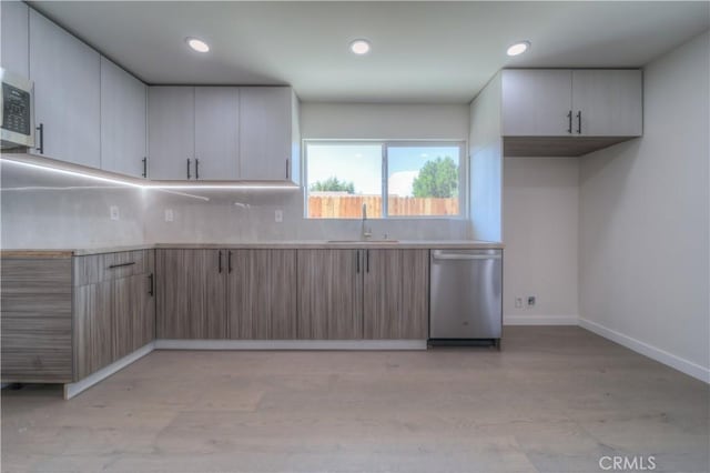 15570 Ethel St, Chino Hills, CA 91709 - kitchen featuring light countertops, decorative backsplash, stainless steel dishwasher, a sink, and baseboards