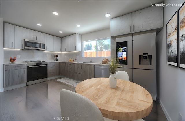 15570 Ethel St, Chino Hills, CA 91709 - kitchen with modern cabinets, appliances with stainless steel finishes, a sink, light countertops, and backsplash