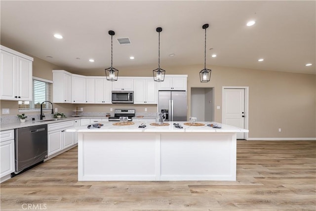 kitchen with pendant lighting, a center island, white cabinets, and stainless steel appliances