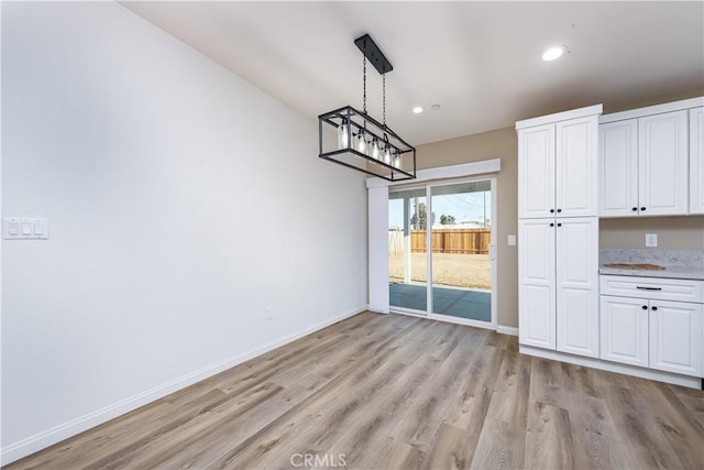 unfurnished dining area featuring light wood-type flooring