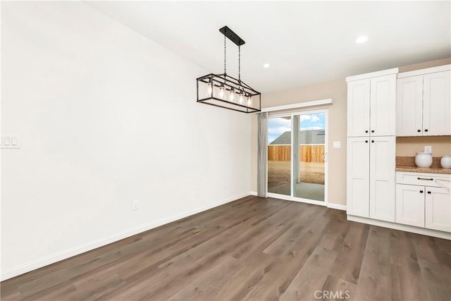 unfurnished dining area with recessed lighting, baseboards, and wood finished floors