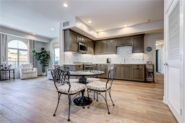 dining space with light hardwood / wood-style flooring and sink