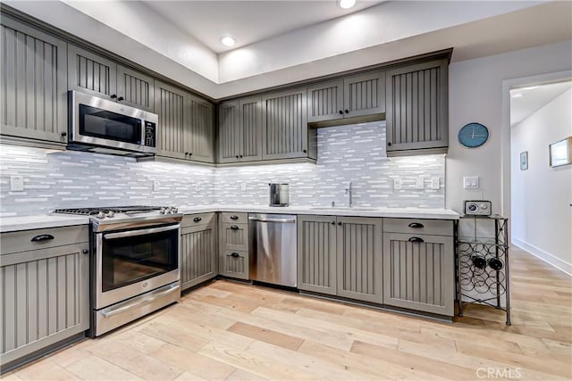 kitchen featuring gray cabinetry, sink, stainless steel appliances, and light hardwood / wood-style floors