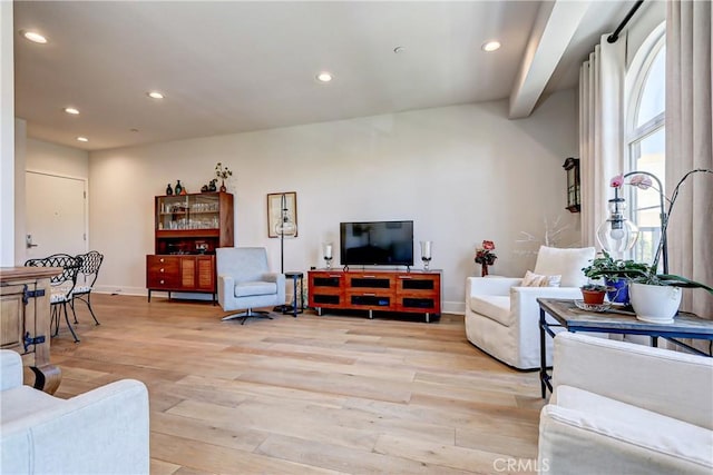 living room with beam ceiling and light wood-type flooring