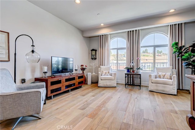 living room with recessed lighting, light wood-style flooring, and baseboards