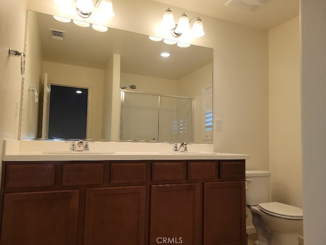 bathroom with vanity, toilet, and a shower with shower door