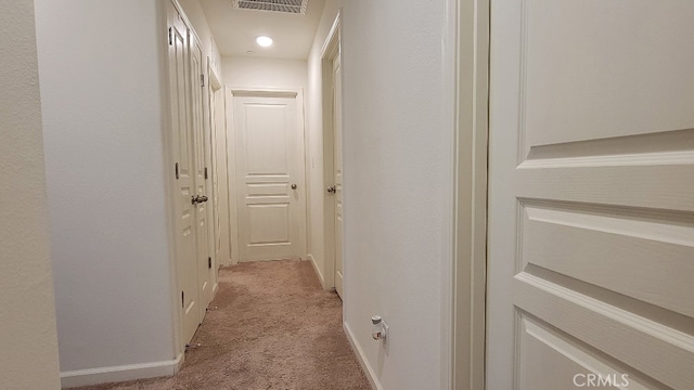 corridor featuring light colored carpet