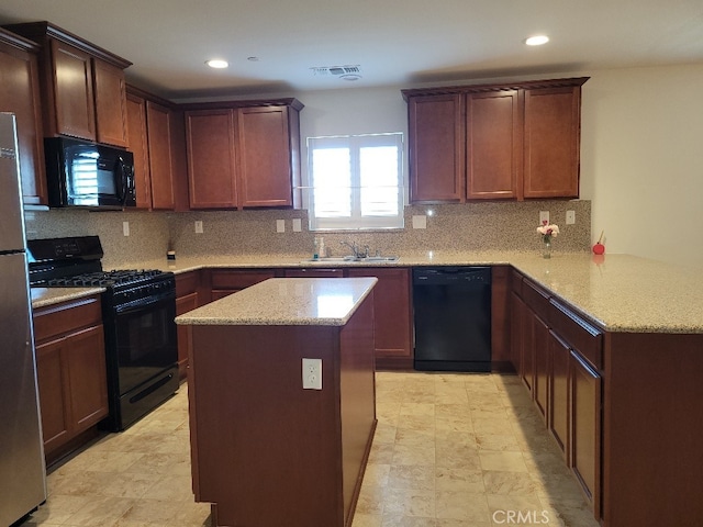 kitchen with black appliances, light stone counters, kitchen peninsula, and tasteful backsplash