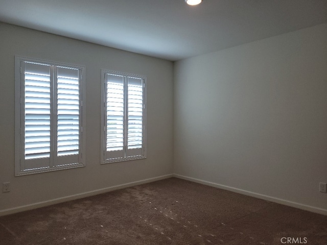 unfurnished room with dark colored carpet